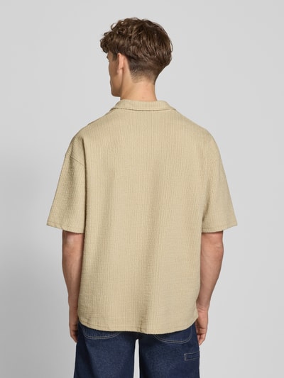 Männermodel trägt Regular Fit Freizeithemd mit Label-Patch Modell 'LIBCO' von Pegador, Material-Mix in Beige, Rückenansicht, Ganzkörperansicht Rückansicht. Rückenlänge bei Größe M: 72 cm, Schulterbreite: 41 cm, Ärmellänge: 35 cm, kurzärmeliges Design, Reverskragen, Knopfleiste, Struktur mit feiner Textur.