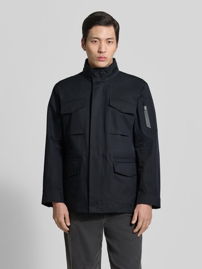 Männermodel trägt Jacke mit Stehkragen und Pattentaschen Modell 'DEFENDER' von G-LAB aus Baumwoll-Mix, Regular-Fit, Ganzkörperansicht von vorne.