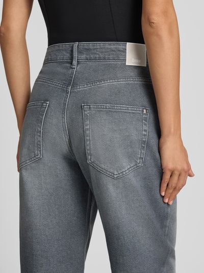 Kobieta nosi szare jeansy Barrel Jeans aus Baumwoll-Mix Modell 'MEGAN S' von Brax, damskie jeansy, detal tylnej części, widok od tyłu