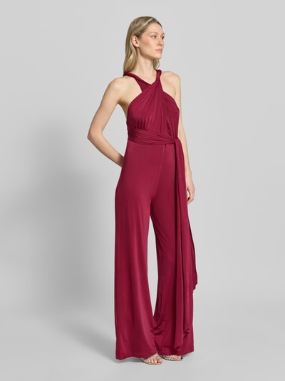 Vrouwenmodel draagt Jumpsuit mit rückseitig gekreuzten Trägern van Rose Avenue, regular fit, diepe V-hals, bordeauxrood, geplooide details, volledige lichaamsvoorzijde.