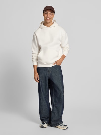 Männermodel trägt Regular Fit Hoodie mit Känguru-Tasche von REVIEW in Weiß aus Baumwoll-Mix, Ganzkörperansicht von vorne. Rückenlänge 70 cm, Ärmellänge 62 cm, Herren HOODIE.