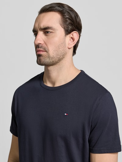 Männermodel trägt Regular Fit T-Shirt Set im 3er-Pack von Tommy Hilfiger, unifarben, Logo-Stitching, Nahaufnahme Oberkörper.
