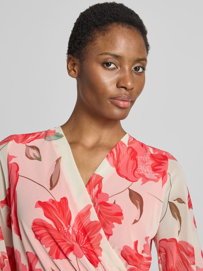 Frauenmodel trägt knielanges Kleid im Allover-Look Modell 'Ja44milaa' von ZABAIONE, rote Blüten, V-Ausschnitt, Nahaufnahme Oberkörper.