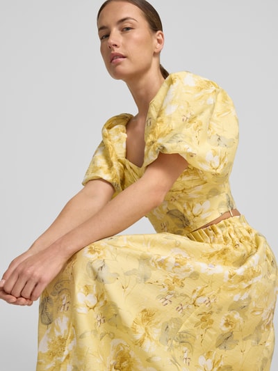 Frauenmodel trägt Cropped Blusentop mit Puffärmeln Modell 'LEMON' von YAS, Lyocell-Mix mit Leinen-Anteil, Allover-Look, Knotendetail, Nahaufnahme Oberkörper.