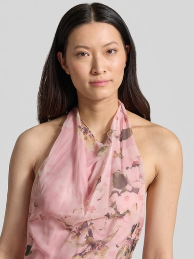 Vrouwenmodel draagt avondjurk met Neckholder en diep rugdecolleté van Mascara in roze chiffon met bloemmotief, nahaufnahme bovenlichaam. Maxi-jurk in A-lijn met haakjessluiting en zij-loopsplit, ruglengte maat 36: 144 cm, borstwijdte: 37 cm.