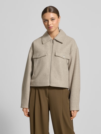 Modelka kobieca ma na sobie Regular Fit Hemdjacke mit Reißverschluss Modell 'FORTUNEFREJ' od Vero Moda, filcowa tkanina, jednolity kolor, kieszenie z patkami, kołnierz koszulowy, zamek, długie rękawy, krój regular fit, widok na całe ciało z przodu.
