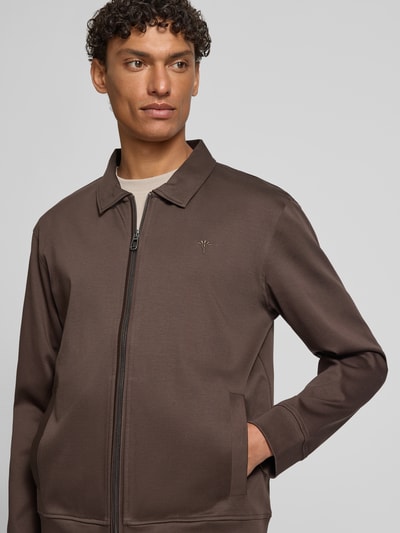 Männermodel trägt Sweatjacke mit Logo-Stitching Modell 'Ricardio' von JOOP! Collection aus brauner Baumwolle, gerader Schnitt, Nahaufnahme Oberkörper.