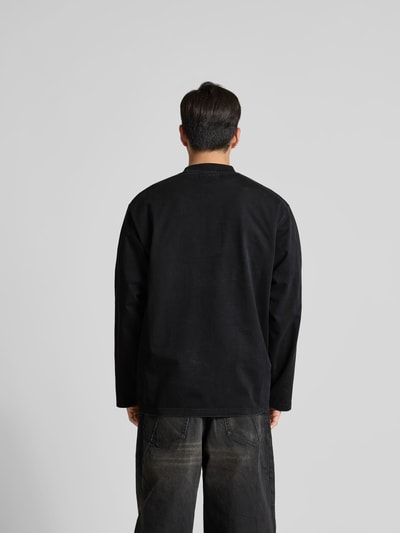 Männermodel trägt Regular Fit Sweatshirt aus Baumwolle von VETEMENTS in Schwarz mit Stehkragen, Statement-Stitching, Langärmelig, Rückenlänge 80 cm, Ganzkörperansicht Rückansicht.