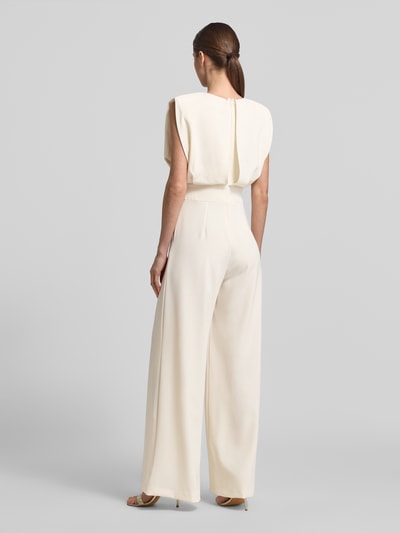 Männermodel trägt Regular Fit Jumpsuit mit Rundhalsausschnitt von Rinascimento, kremowy, bez rękawów, krój regular fit, fałdy, całkowita długość 150 cm, szerokość w rozmiarze S 45 cm, długość wewnętrzna nogawki 86 cm, perspektywa: całkowita sylwetka z tyłu.