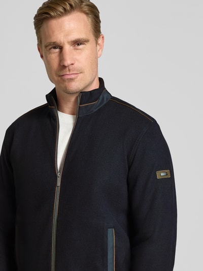 Männermodel trägt Sweatjacke mit Label-Details von bugatti in Dunkelblau mit Stehkragen, Reißverschluss, Nahaufnahme Oberkörper, Baumwollmischung.