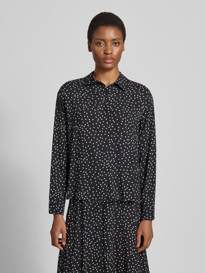 Modelka nosi bluzkę koszulową Regular Fit Hemdbluse aus reiner Viskose Model 'GILDA' od Soyaconcept, czarna w białe kropki, krój regular fit, kołnierzyk koszulowy, długi rękaw, listwa guzikowa na całej długości, długość tyłu w rozmiarze S: 57 cm, długość rękawów w rozmiarze S: 57 cm, widok całej sylwetki od przodu.
