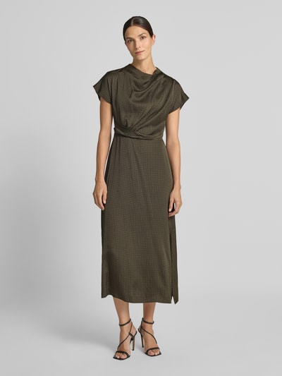 Frauenmodel trägt Fließendes Freizeitkleid mit Allover-Muster von Jake*s aus der Jake*s Collection in Olivtönen mit feinen Punkten, Ganzkörperansicht von vorne.