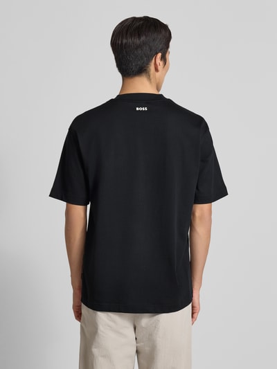 Männermodel trägt Regular Fit T-Shirt aus Baumwoll-Mix Modell 'TEETIM' von BOSS Orange, Optik: Unifarben, Label-Print, Ganzkörperansicht Rückansicht.