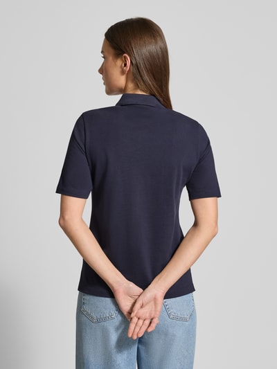 Frauenmodel trägt Poloshirt aus Baumwolle mit Label-Detail von GANT in Dunkelblau, gerader Schnitt, Polokragen, 1/2-Arm, Rückenlänge 59 cm, Ganzkörperansicht Rückansicht.