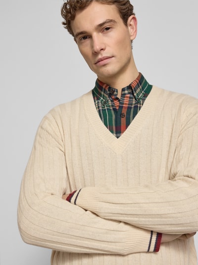 Männermodel trägt Kaschmirpullover mit gerippten Abschlüssen von FTC-Cashmere in Beige, V-Ausschnitt, Regular Fit, Nahaufnahme Oberkörper.