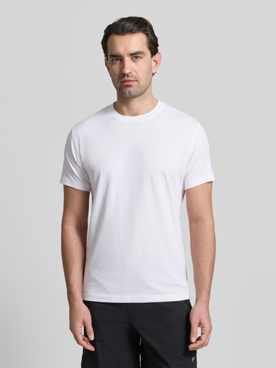 Męski model nosi Slim Fit T-Shirt mit Rundhalsausschnitt od Fabletics, biały, krój slim fit, bawełna z modalem, krótki rękaw, widok z przodu, ujęcie całej sylwetki.