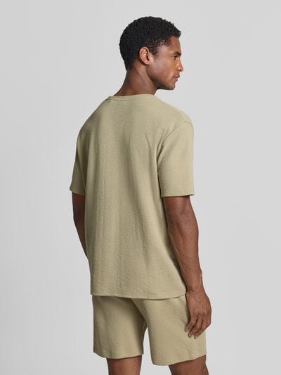 Männermodel trägt Regular Fit T-Shirt aus Baumwoll-Mix von BOSS in Beige mit Waffelstruktur, unifarben, Kurzarm, Ganzkörperansicht Rückansicht.