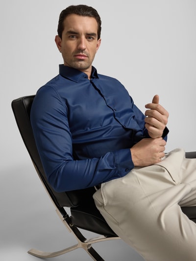 Mężczyzna nosi Slim Fit Business-Hemd mit Kentkragen und extra langem Ärmel von Jake*s, niebieski materiał z dodatkiem stretchu, krój slim fit, widok z przodu, ujęcie zbliżeniowe na górną część ciała. Długość tyłu w rozmiarze 39/40: 80 cm, szerokość w rozmiarze 39/40: 44 cm, długość rękawa w rozmiarze 39/40: 71 cm.