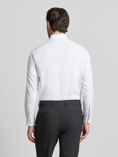 Męski model nosi Regular Fit Business Hemd aus Baumwolle mit Kentkragen von Christian Berg Men, biała bawełna, krój regular fit, kołnierzyk kent, listwa guzikowa, długość tyłu w rozmiarze 39/40: 78 cm, szerokość ramion w rozmiarze 39/40: 47 cm, długość rękawa w rozmiarze 39/40: 64 cm, widok całej sylwetki z tyłu.