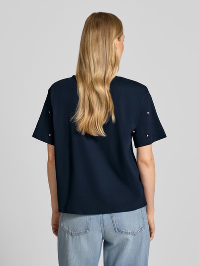 Frauenmodel trägt Boxy Fit T-Shirt aus reiner Baumwolle von Tom Tailor Denim in Dunkelblau mit Herz-Stickerei, unifarben, Rückansicht Ganzkörperansicht.