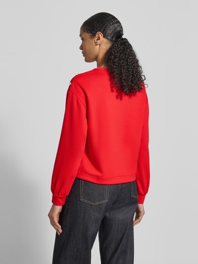 Frauenmodel trägt Sweatshirt mit Viskose-Anteil von monari in Rot, lockere Passform, elastische Ärmel, Ganzkörperansicht Rückansicht.