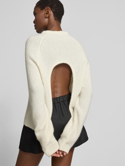 Frauenmodel trägt Regular Fit Pullover aus Alpaka-Mix von black palms in Strick-Optik mit Rundhalsausschnitt, Rückenlänge 60 cm, Ganzkörperansicht Rückansicht.