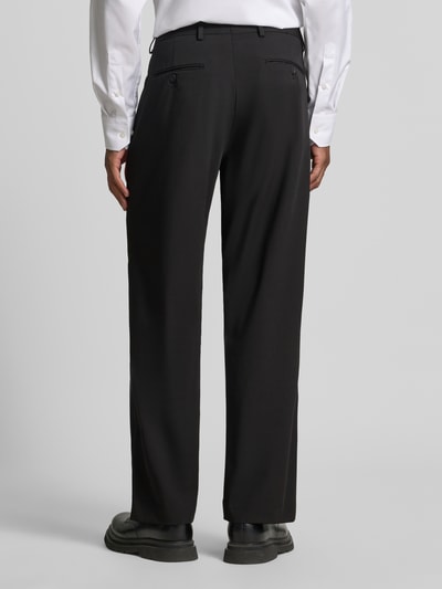 Männermodel trägt schwarze Loose Fit Anzughose mit Gürtelschlaufen Modell 'LOOSE-LIAM' von Selected, Herren Anzughose, Ganzkörperansicht Rückansicht.