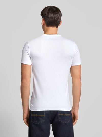 Männermodel trägt T-Shirt mit Label-Stitching von Polo Ralph Lauren in Weiß, reine Baumwolle, Regular Fit, Ganzkörperansicht Rückansicht.