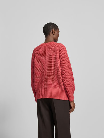 Frauenmodel trägt Pullover aus Woll-Mix in Strick-Optik von Joseph in Rot mit geripptem Rundhalsausschnitt, lockere Passform, Rückenlänge 120 cm, Woll-Kaschmir-Mix mit Seide-Anteil, Gerippte-Abschlüsse, Ganzkörperansicht Rückansicht.