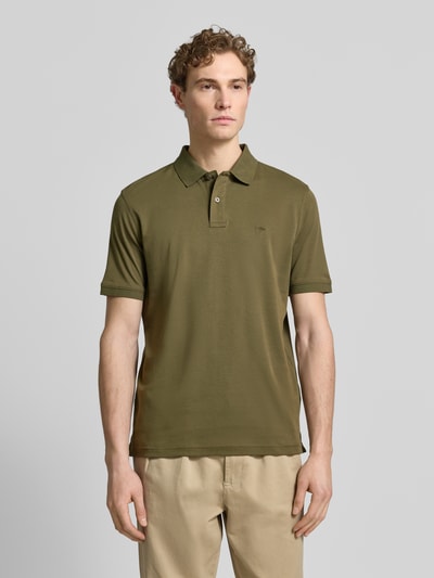 Männermodel trägt Regular Fit Poloshirt mit Logo-Stitching von Fynch-Hatton in Olivgrün, reine Baumwolle, Ganzkörperansicht von vorne.