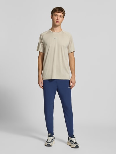 Männermodel trägt Slim Fit Trainingshose mit Dri-FIT-Technologie Modell 'Stride' von Nike, Herren Trainingshose, Ganzkörperansicht von vorne.