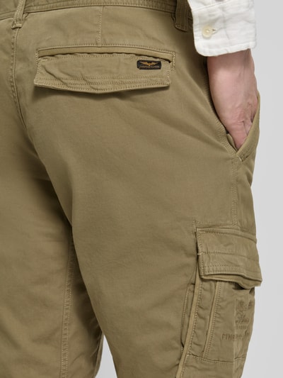 Männermodel trägt Bermudas mit Pattentaschen und Label-Stitchings von PME Legend in Khaki mit Motiv- und Label-Stitchings, Detailaufnahme Rückansicht. Bundweite 41 cm, Innenbeinlänge 26 cm, Seitliche Eingrifftaschen und Klettverschluss.