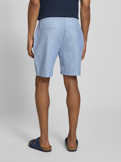 Männermodel trägt Shorts mit elastischem Bund von Scotch & Soda im Baumwoll-Leinen-Mix, hellblau, Regular Fit, Ganzkörperansicht Rückansicht.