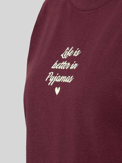 Frauenmodel trägt Regular Fit Pyjama-Oberteil mit Statement-Print von Jake*s Casual in Bordeaux mit cremefarbenem Print, Reine Baumwolle, Rundhalsausschnitt, Nahaufnahme Oberkörper.
