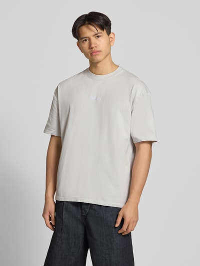 Männermodel trägt Oversized T-Shirt mit 1/2-Arm Modell 'Towson' von Pegador, hellgraue Baumwolle, Rundhalsausschnitt, Ganzkörperansicht von vorne.
