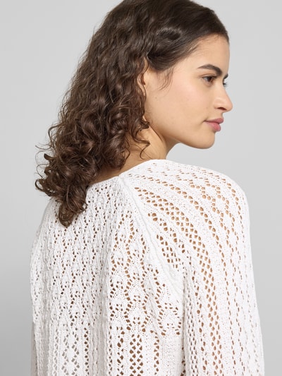 Frauenmodel trägt Regular Fit Strickpullover aus recyceltem Baumwoll-Mix Modell 'NOLA LIFE' von Only, weißes Lochstrickmuster, Nahaufnahme Oberkörper.