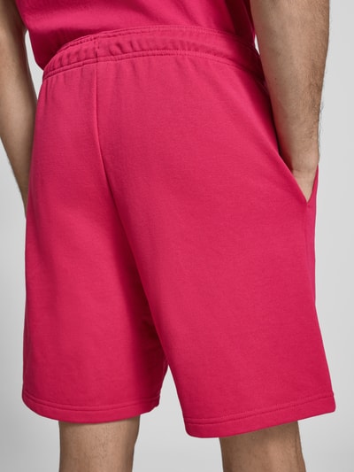 Männermodel trägt Sweatshorts mit Logo und elastischem Bund von CHAMPION, regular fit, katoenmix, logo, elastische tailleband, tunnelkoord, detailopname rugzijde