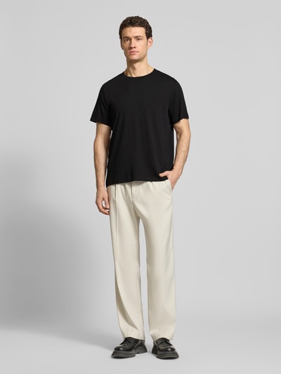 Männermodel trägt Regular Fit T-Shirt aus reiner Baumwolle Modell 'HASPEN' von SELECTED HOMME in Melange-Optik, Rundhals, Kurzarm, Ganzkörperansicht von vorne.