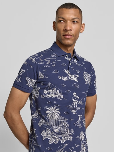 Męski model nosi Regular Fit Poloshirt aus reiner Baumwolle von Polo Ralph Lauren, efekt: wzór na całej powierzchni, krój regular fit, wzór: marynistyczny nadruk polo bear, wyhaftowane logo, kołnierzyk polo, rękaw: krótki rękaw, zakończenia rękawów: prążkowane, materiał: bawełna, kolor: granatowy z białym wzorem. Nahaufnahme górnej części ciała z przodu.