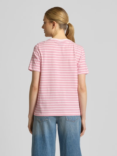Kobiece model prezentuje Regular Fit T-Shirt aus reiner Baumwolle Modell 'PAULINA' od Vero Moda z różowo-białym prążkowanym wzorem, jersey; całopostaciowy widok z tyłu.