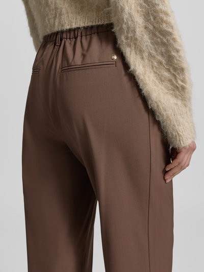 Vrouwenmodel draagt Hose aus Viskose-Mix Modell 'Bai Roy' van MOS MOSH, met stretch, slim fit, elastische band, achterzakken, detailopname achteraan.