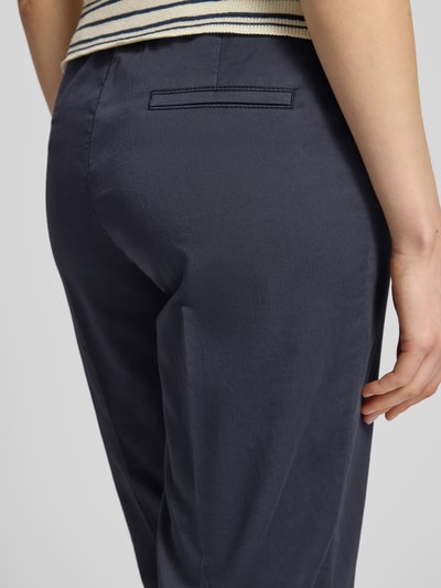 Frauenmodel trägt Wide Fit Stoffhose in 7/8-Länge Modell 'Sue' von TONI aus Baumwoll-Mix mit Eingrifftaschen, Detailaufnahme Rückansicht.
