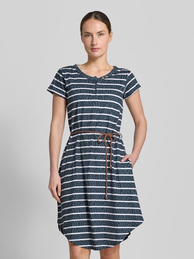 Frauenmodel trägt Knielanges T-Shirt-Kleid mit Bindegürtel von G.I.G.A. DX aus Reine Baumwolle, Gerader-Schnitt, Rundhalsausschnitt, Knopfleiste, Bindegürtel, Knielänge, mit Streifenmuster, Blau-Weiß, Ganzkörperansicht von vorne