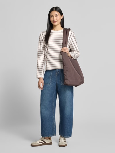 Frauenmodel trägt Boxy Fit Langarmshirt aus reiner Baumwolle Modell 'ESSENTIAL' von Selected, creme mit braunen Streifen, kombiniert zu blauen Jeans, Damen Langarmshirt von Selected, Ganzkörperansicht von vorne.