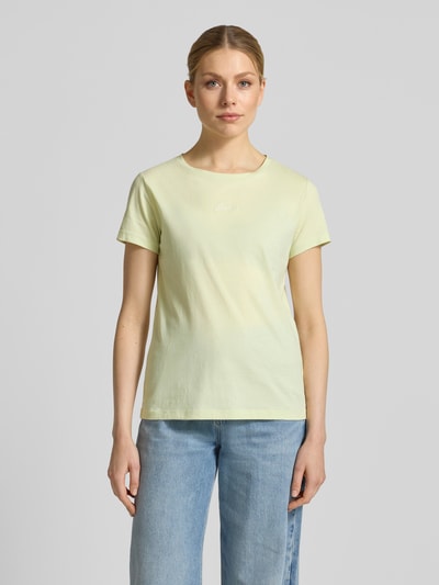 Frauenmodel trägt Slim Fit T-Shirt aus reiner Baumwolle Modell 'ELOVE_EMBRO' von BOSS Orange in Hellgelb, unifarben, Label-Stitching, Ganzkörperansicht von vorne.
