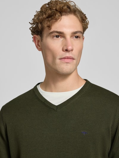 Männermodel trägt Strickpullover mit Label-Strickerei von Fynch-Hatton in Olivgrün, Baumwolle, V-Ausschnitt, Nahaufnahme Oberkörper.