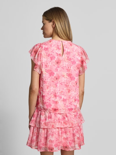 Frauenmodel trägt Regular Fit Top aus Chiffon Modell 'SMILLA' von Vero Moda mit Optik:Allover-Muster in Rosatönen, Kurzarm, Schmetterlingsärmel, Knopf und Öse, Materialverarbeitung: Chiffon, Ganzkörperansicht Rückansicht.