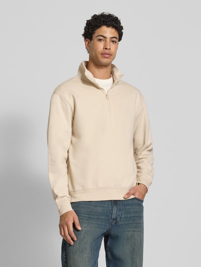 Männermodel trägt Sweatshirt mit Troyer-Kragen Modell 'BRODY' von Blend, beiger Baumwoll-Mix, gerader Schnitt, Nahaufnahme Oberkörper.