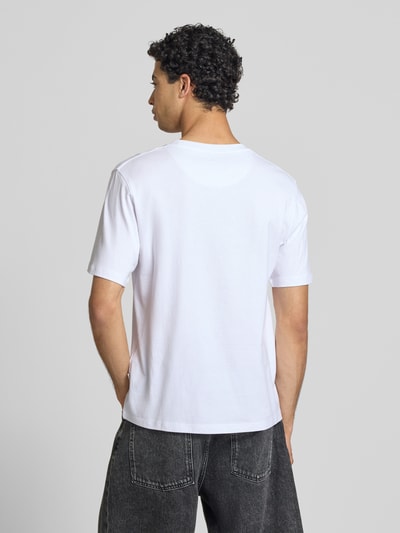 Männermodel trägt Regular Fit T-Shirt mit Statement-Print Modell 'Eres' von Jack & Jones aus reiner Baumwolle, Ganzkörperansicht Rückansicht.