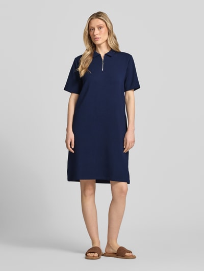 Frauenmodel trägt Polokleid mit kurzem Reißverschluss von Christian Berg Woman, dunkelblau, Material-Mix mit Modal-Anteil, Gerader-Schnitt, Midikleid, Polokragen, Ganzkörperansicht von vorne.
